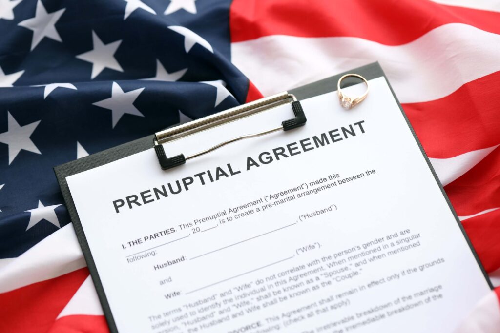 Prenuptial agreement and wedding ring on the table. Prenuptial paperwork process in the United States close up Prenuptial agreement and wedding ring on the table. Prenuptial paperwork process in the United States close up