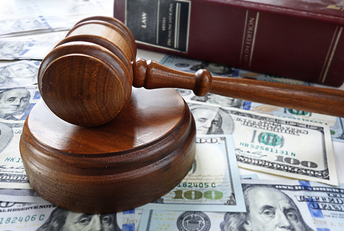 Gavel Over Money Gavel Sitting Over Spread Dollar Bills and the Book Titled Law on the Side
